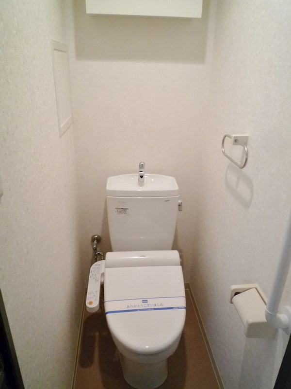ウォシュレット付きのトイレ。背面には便利な収納棚が設置済み。