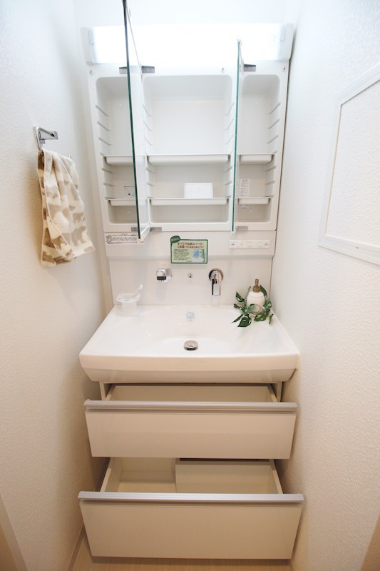 洗面台はスライド式の収納を採用し、3面鏡裏も収納スペースになっています。