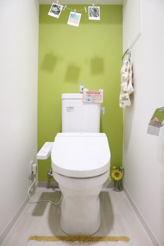 グリーンの壁紙がとってもおしゃれなトイレ。もちろん温水洗浄暖房便座付きです。