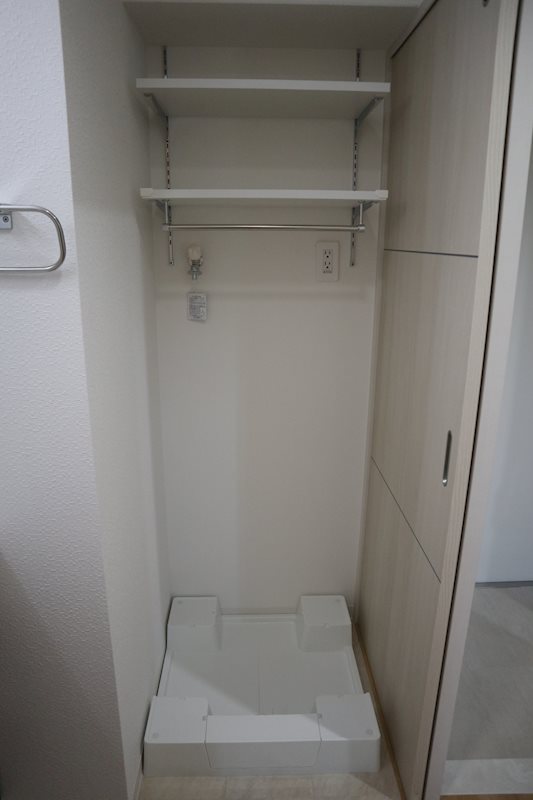 洗濯機置場。上部に収納として利用できる棚を設置。